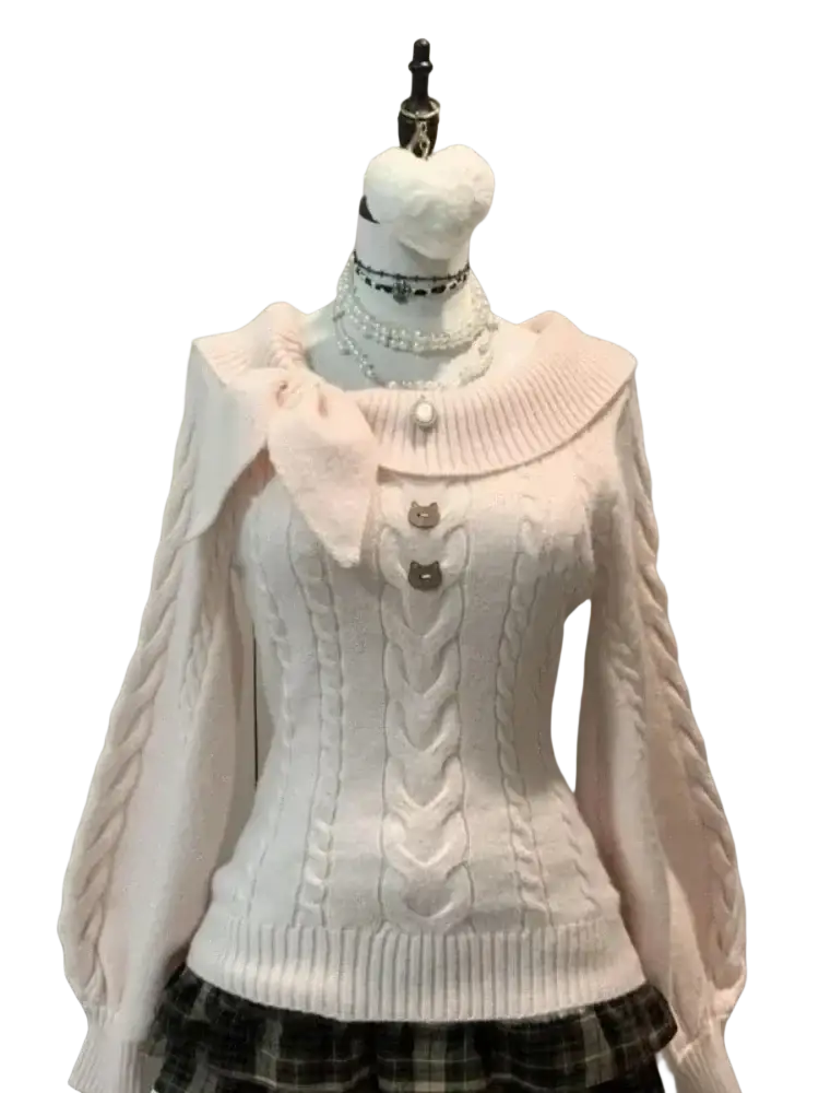 A soft pink oversized knit sweater with ribbed collar cable knit front and twisted braid long sleeves for winter wear
