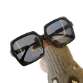 Oversized square fashion sunglasses with black glossy frames and dark gray lenses for stylish sun protection