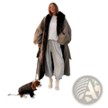 A woman wearing an oversized beige trench coat with a dark brown fur-lined hood stands on a paved promenade