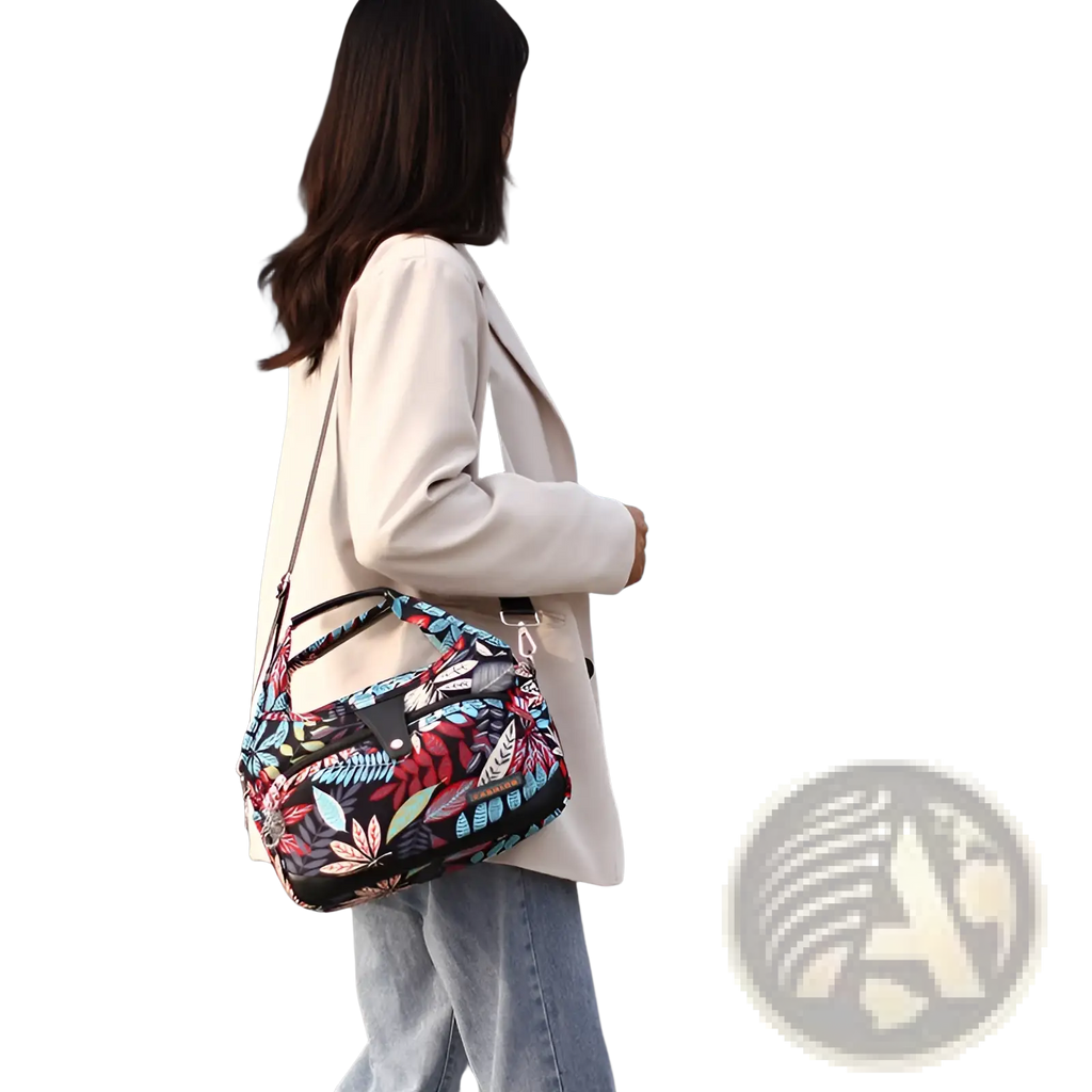 Oxford cloth floral messenger bag with a black base featuring colorful leaves and feathers in vibrant reds blues and greens