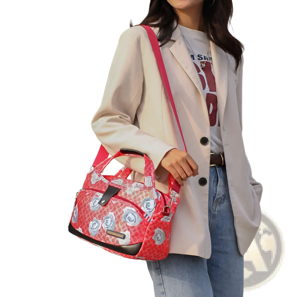 A vibrant red oxford cloth floral messenger bag with silver roses and black accents designed for casual wear