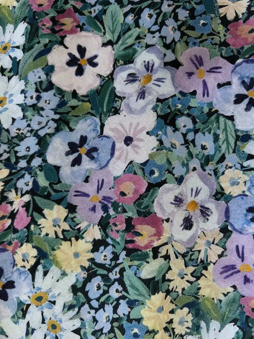 A 1950s painted floral cotton a-line midi dress with pockets featuring pastel pansies and daisies on green leaves