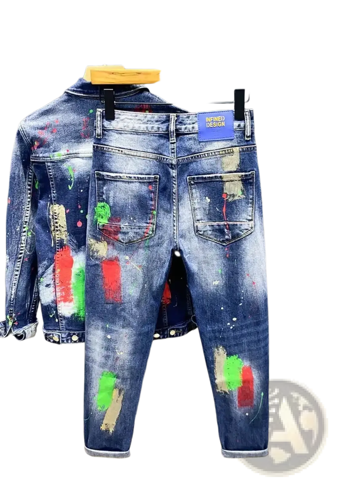 Painted ripped denim jeans for men in blue with colorful paint splatter design hanging on a wooden hanger