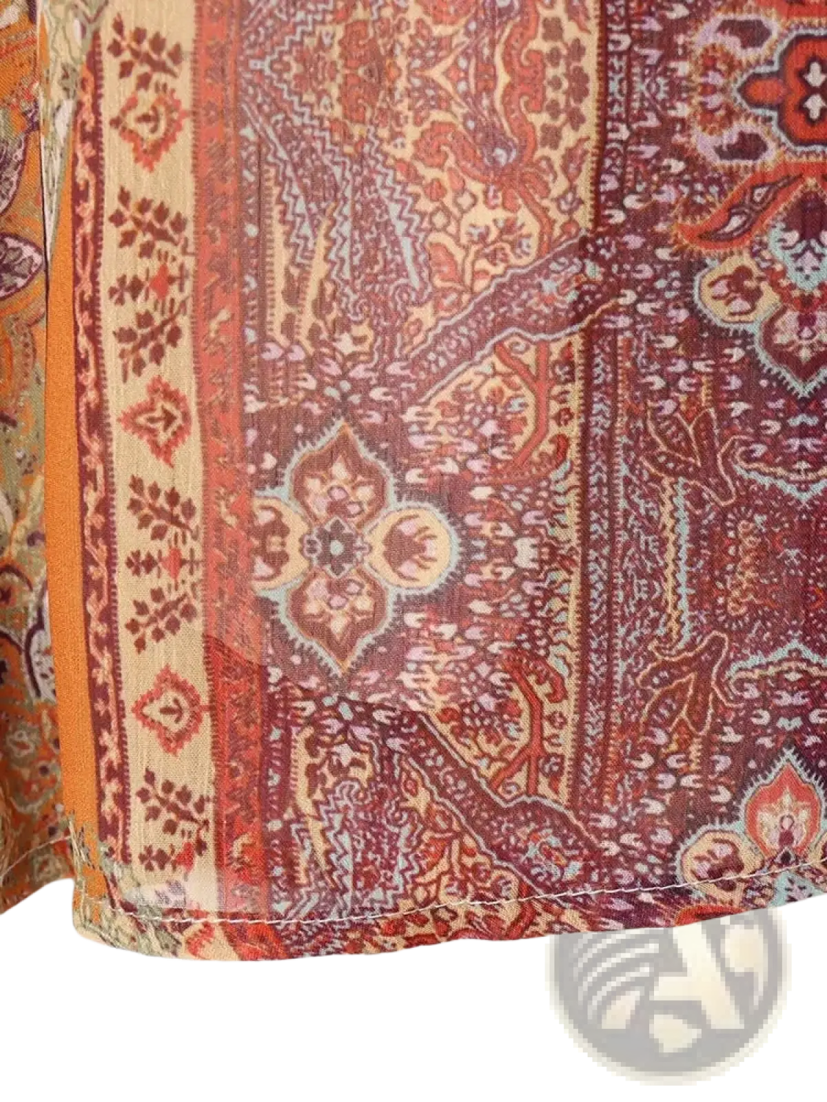 A vibrant paisley print high waist midi skirt made of sheer fabric in red and orange tones