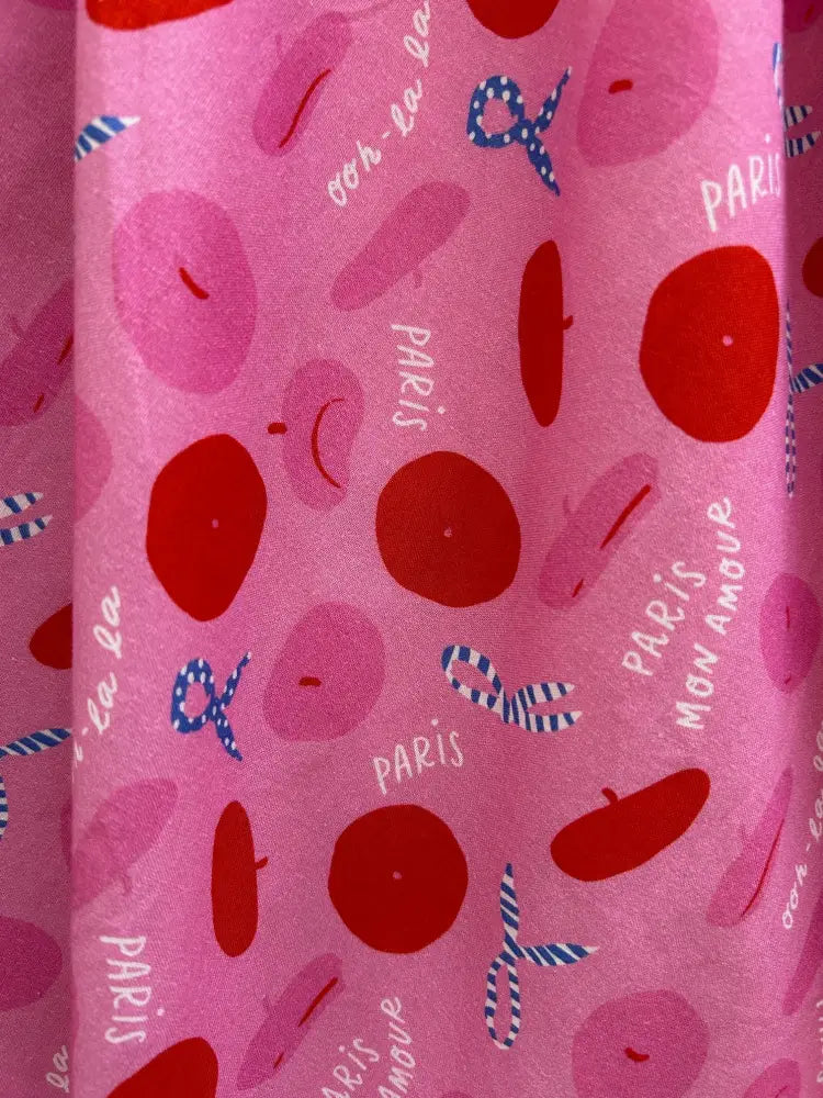 Pink retro pleated cotton skirt with pockets featuring playful beret and paris script pattern on soft pink fabric