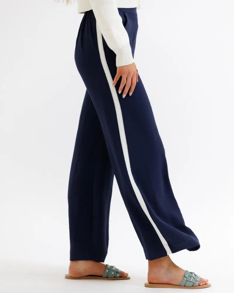 Parisian high waist navy wide leg pleated trousers with white vertical stripe detail on the side in a front view