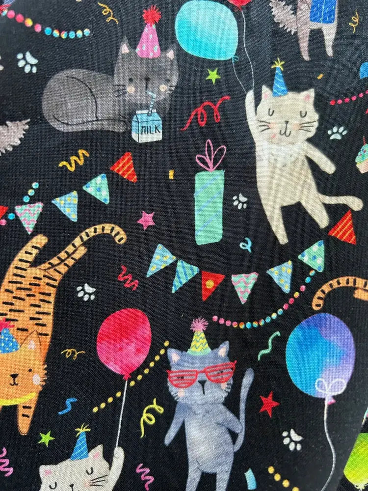 Party cats retro cotton skater skirt with black fabric featuring playful cartoon cats wearing party hats and holding balloons and gifts