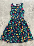 A vibrant sleeveless navy cotton dress featuring colorful orange green and red dinosaurs for vintage party wear