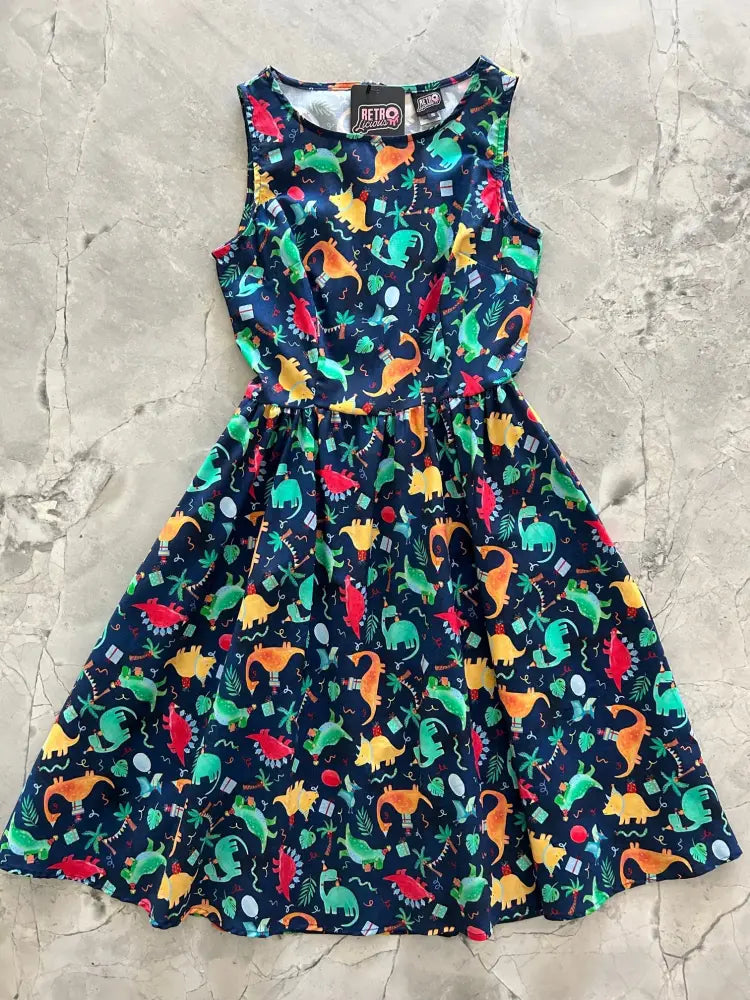 A vibrant sleeveless navy cotton dress featuring colorful orange green and red dinosaurs for vintage party wear