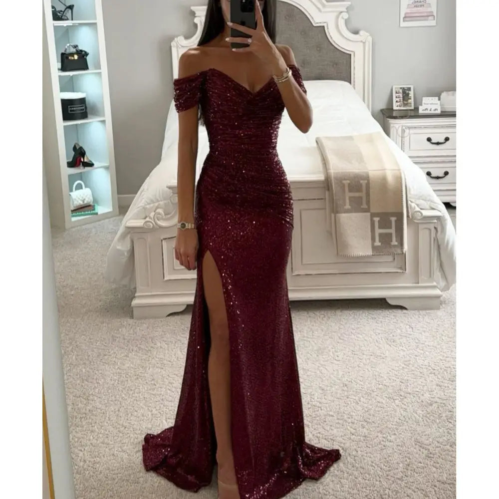 Off the shoulder mermaid gown in shimmering burgundy sequins with a high slit and split detail