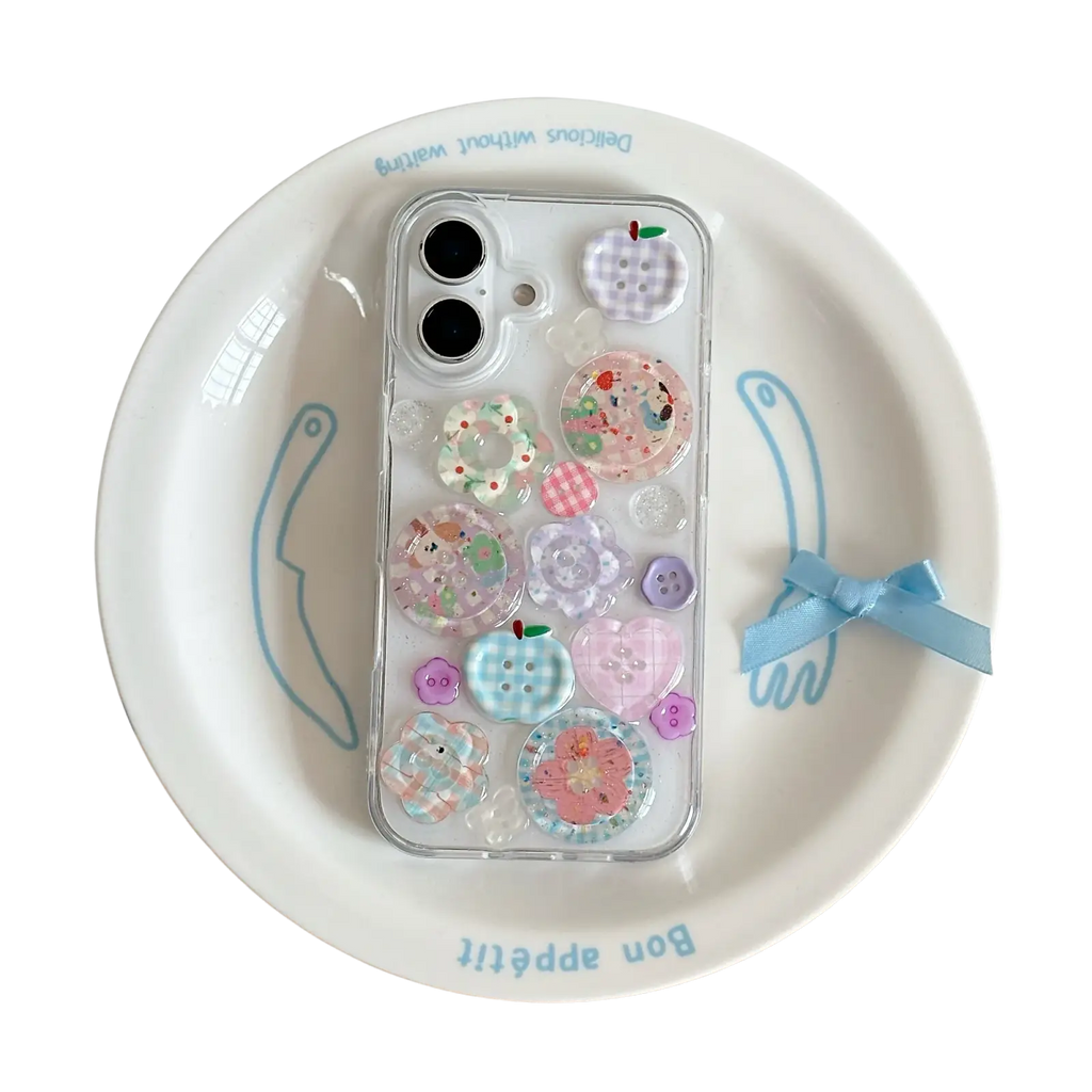 A clear iphone case decorated with pastel pink blue and purple decorative buttons shown from the back side
