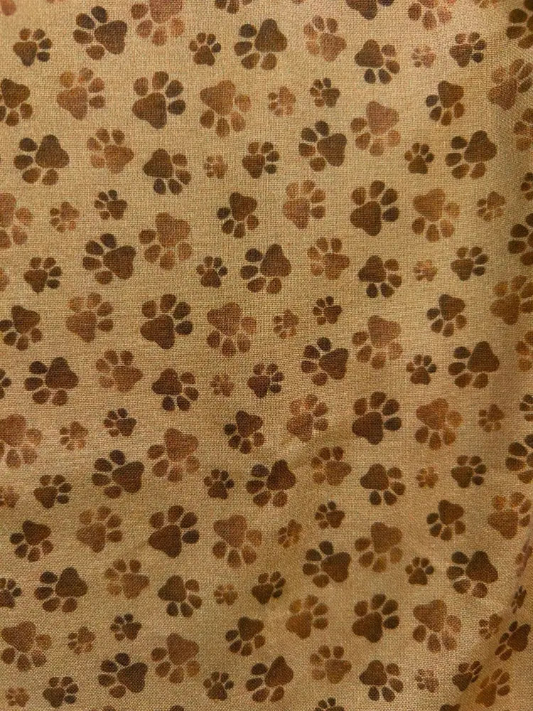Tan sleeveless cotton top with vintage brown paw print pattern in varying shades on fabric