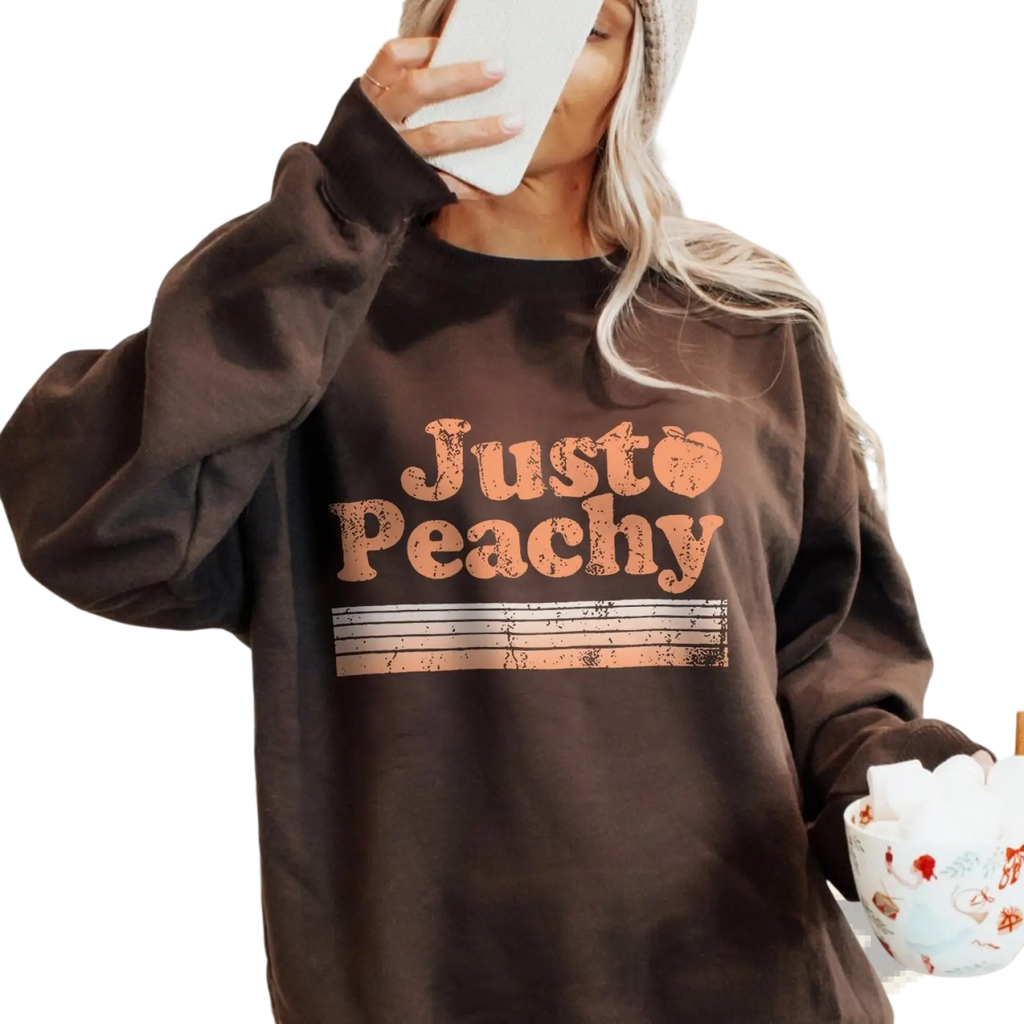 A cozy dark brown oversized sweatshirt with distressed orange just peachy graphic and horizontal stripes
