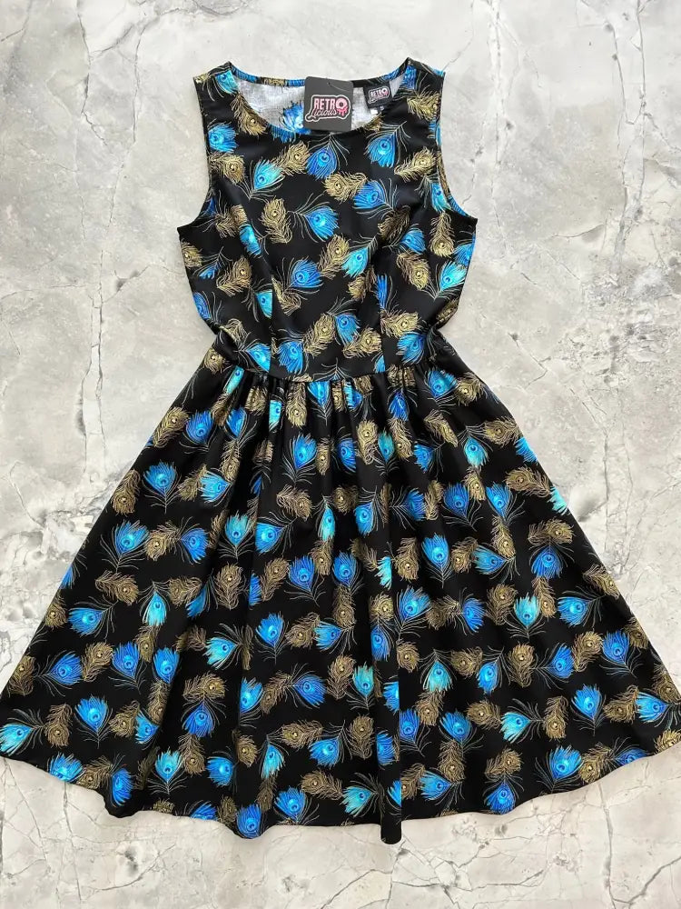 Black sleeveless vintage A-line cotton dress with vibrant blue and gold peacock feather pattern and fitted bodice