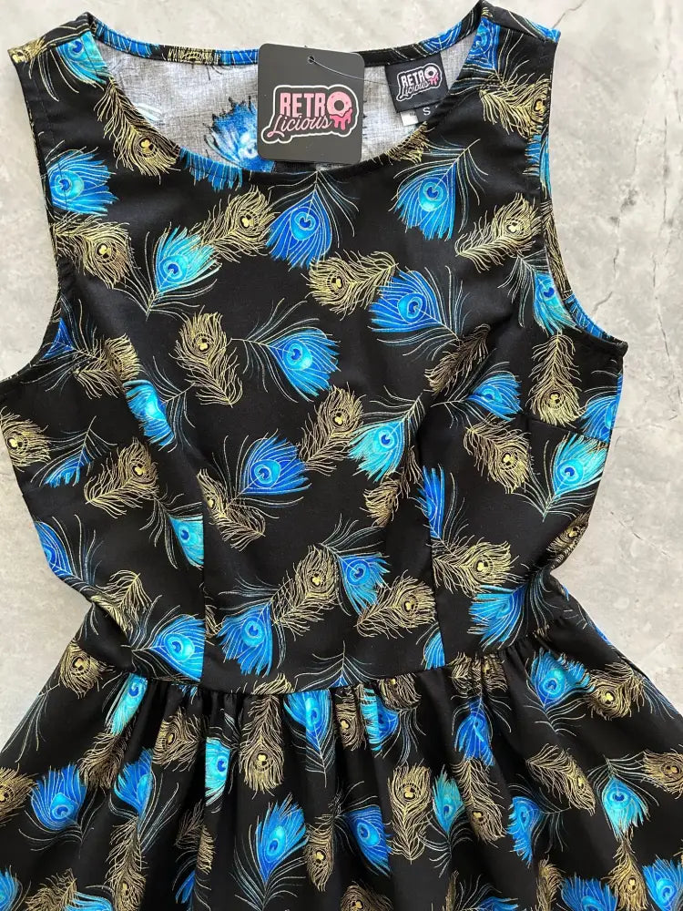 Black sleeveless vintage A-line cotton dress with vibrant blue and gold peacock feather pattern