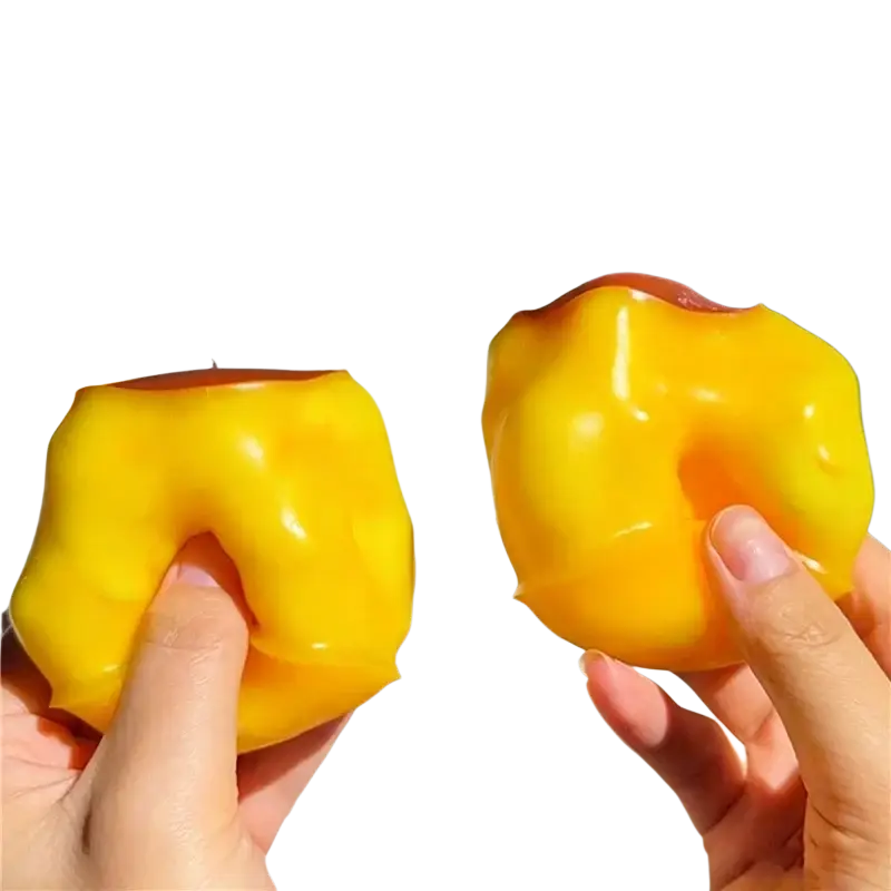 Glossy yellow peach-shaped peanut stress ball sensory fidget toy with a red top resembling a miniature caramel flan
