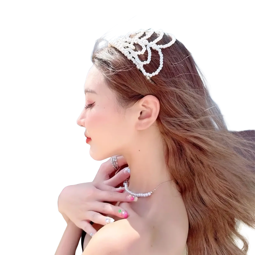 A delicate white pearl bridal crown hair band featuring an intricate floral design and elegant tassel accents