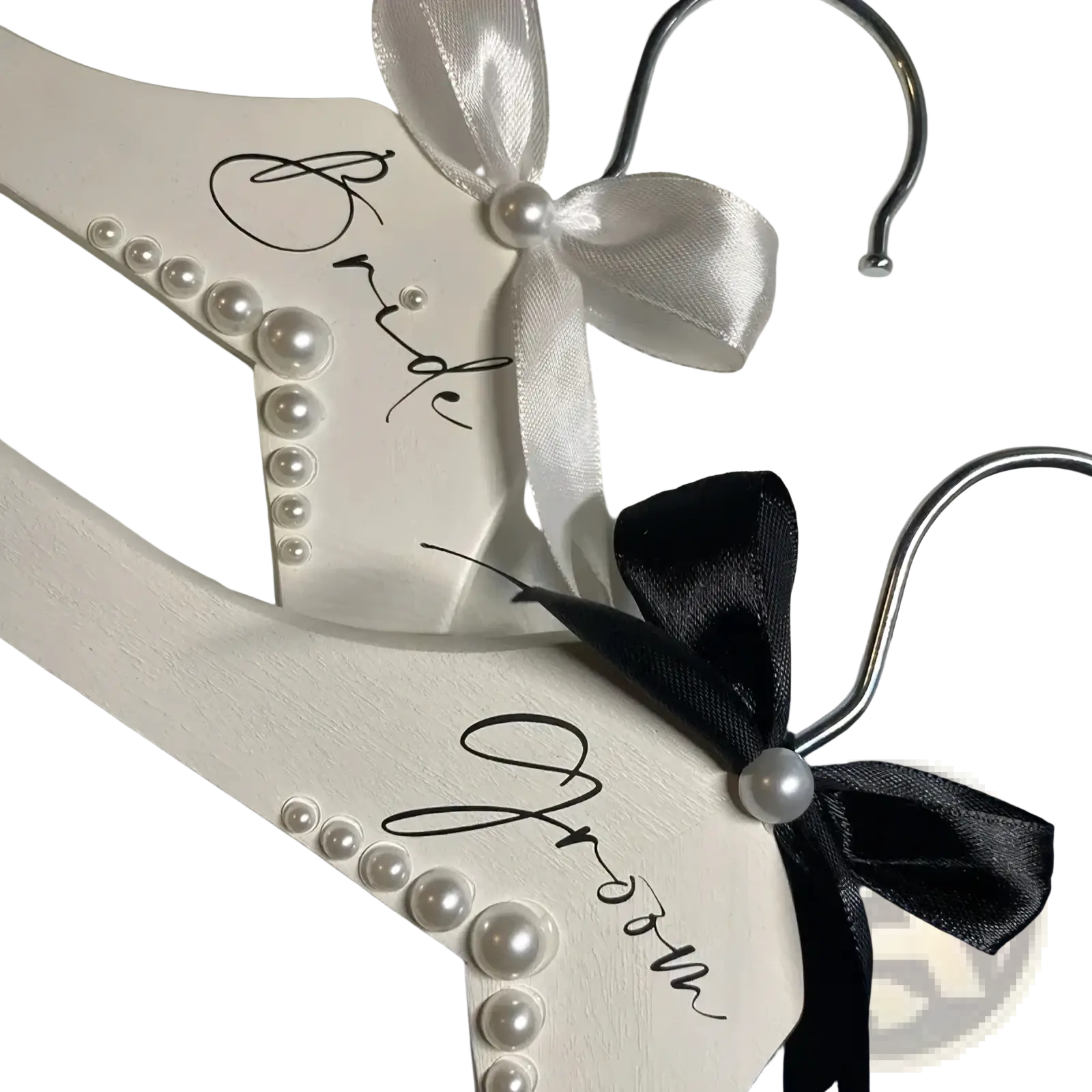 White wooden pearl bride and groom wedding hangers set with satin bows for bridal attire display
