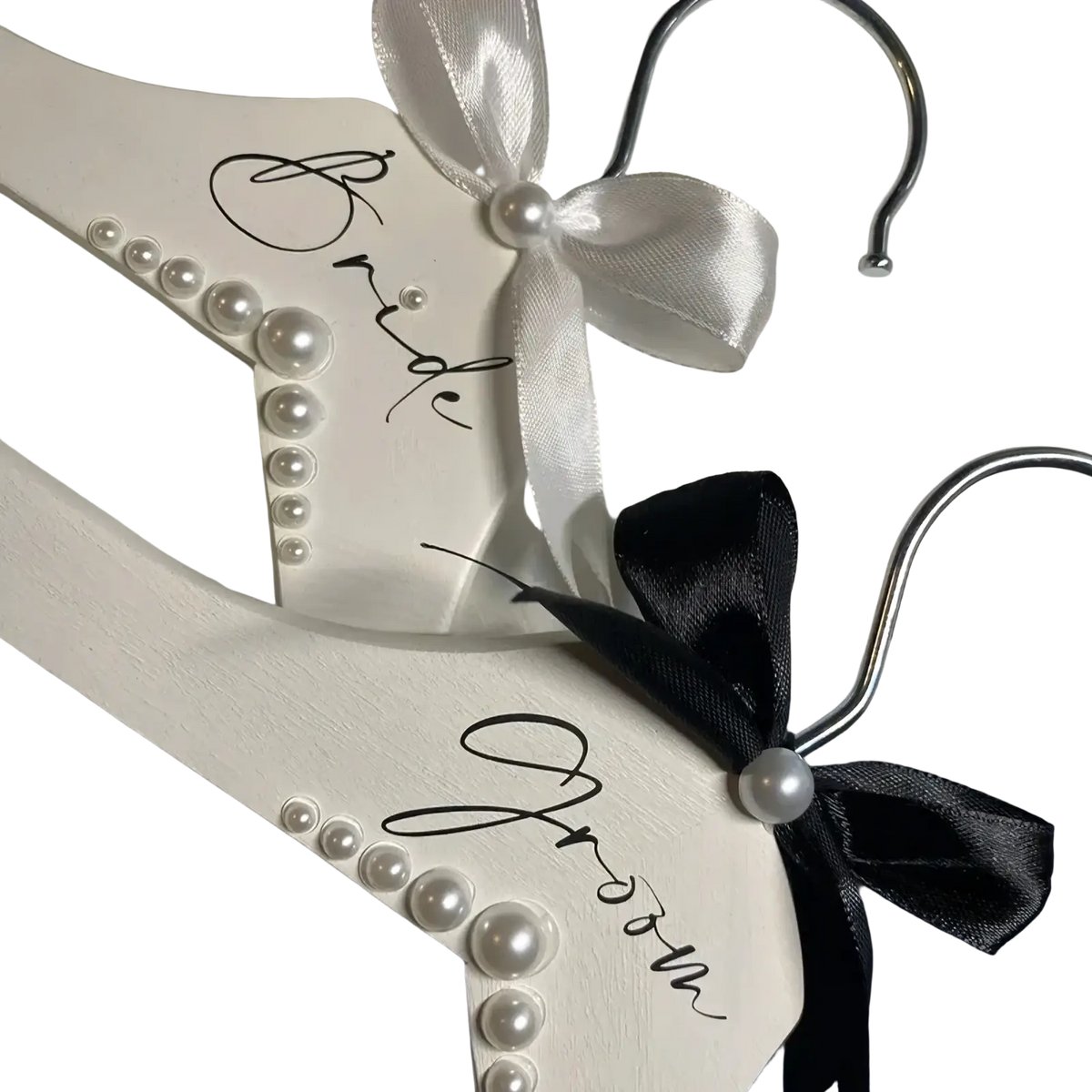 White wooden pearl bride and groom wedding hangers set with satin bows for bridal attire display