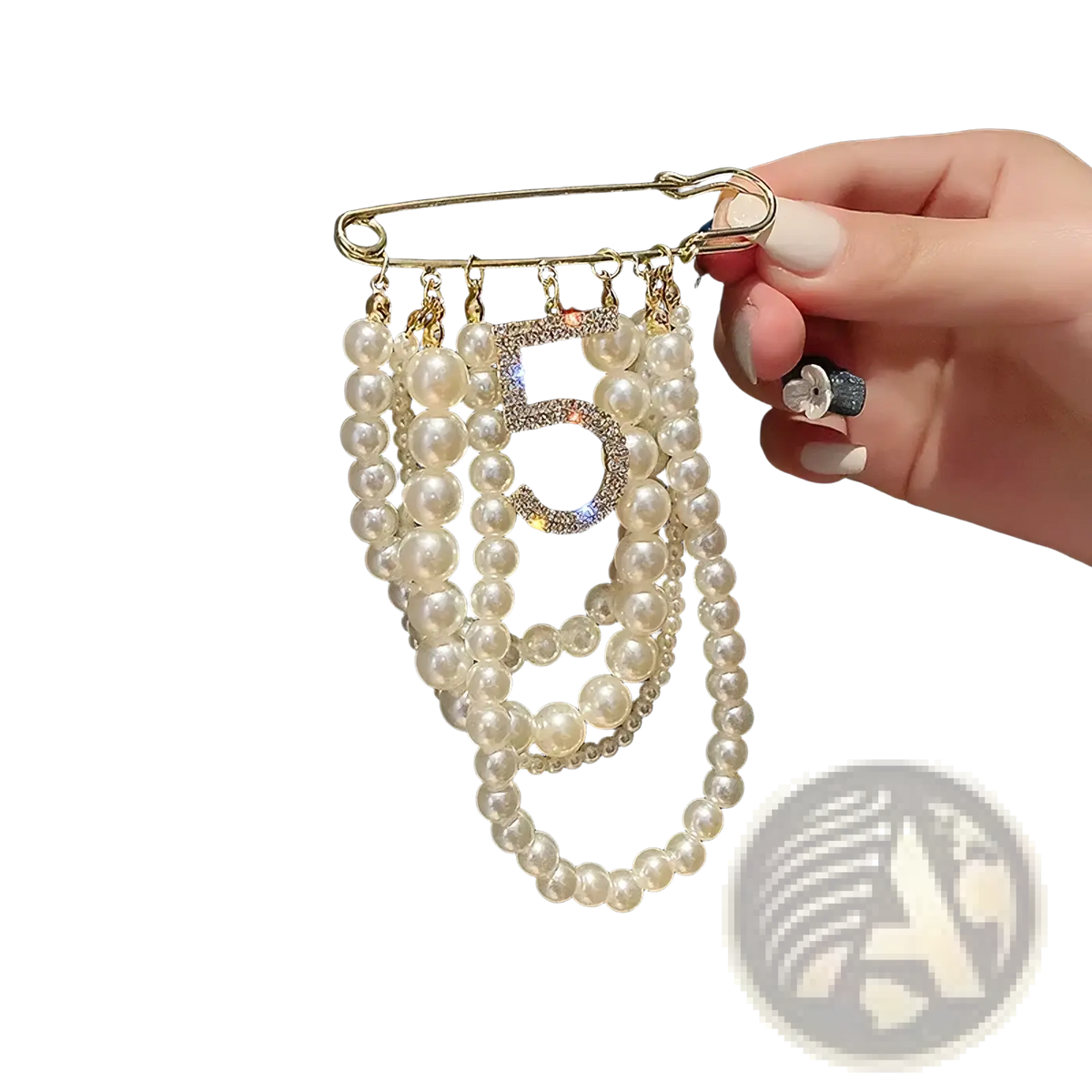 A gold safety pin brooch with white pearl strands and a rhinestone encrusted number 5 centerpiece