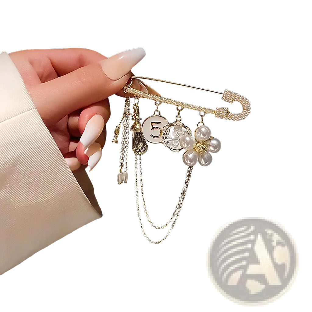 A gold-toned safety pin brooch with sparkling rhinestones and dangling pearl flower and number 5 charms