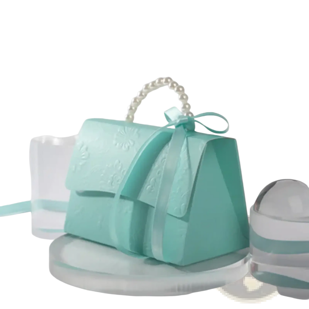A delicate mint green paper handbag with a pearl handle and satin bow for party favor gift box candy packaging
