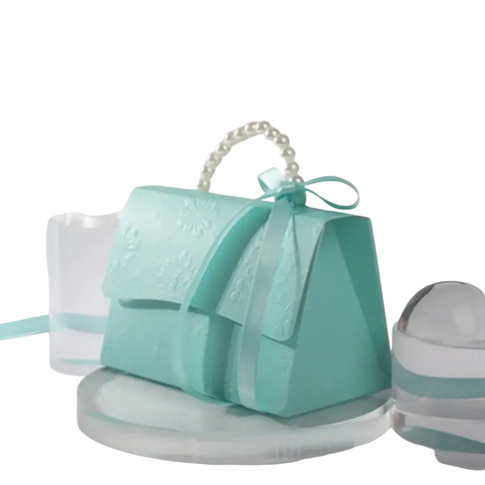 A delicate mint green paper handbag with a pearl handle and satin bow for party favor gift box candy packaging