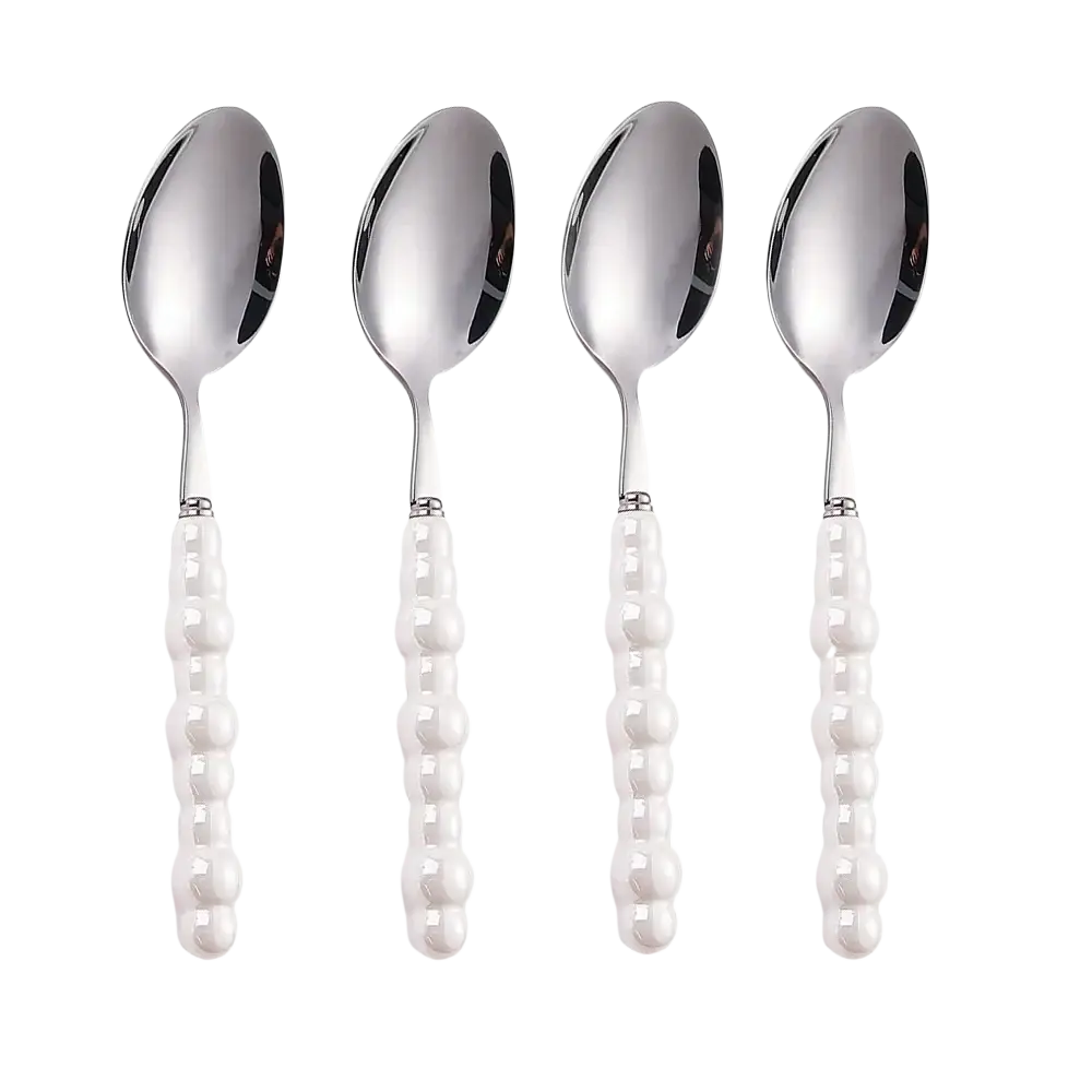 Set of four elegant silver stainless steel spoons with pearl like white beaded handles for dining use