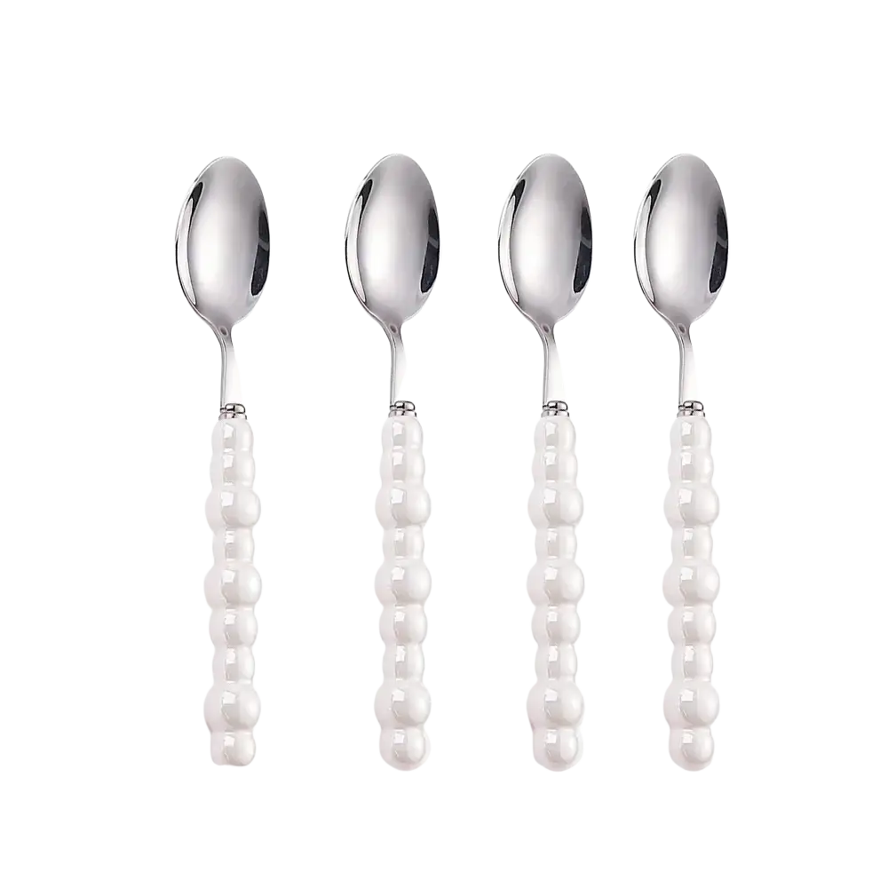 Set of four elegant silver stainless steel spoons with white beaded pearl handles in a cutlery set