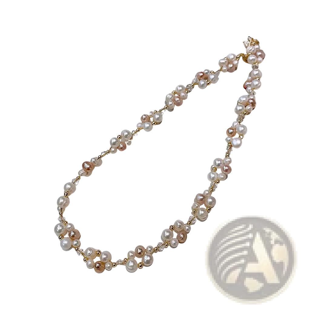 A delicate pearl necklace with white and pink freshwater pearls and gold beads on a 14k gold filled chain