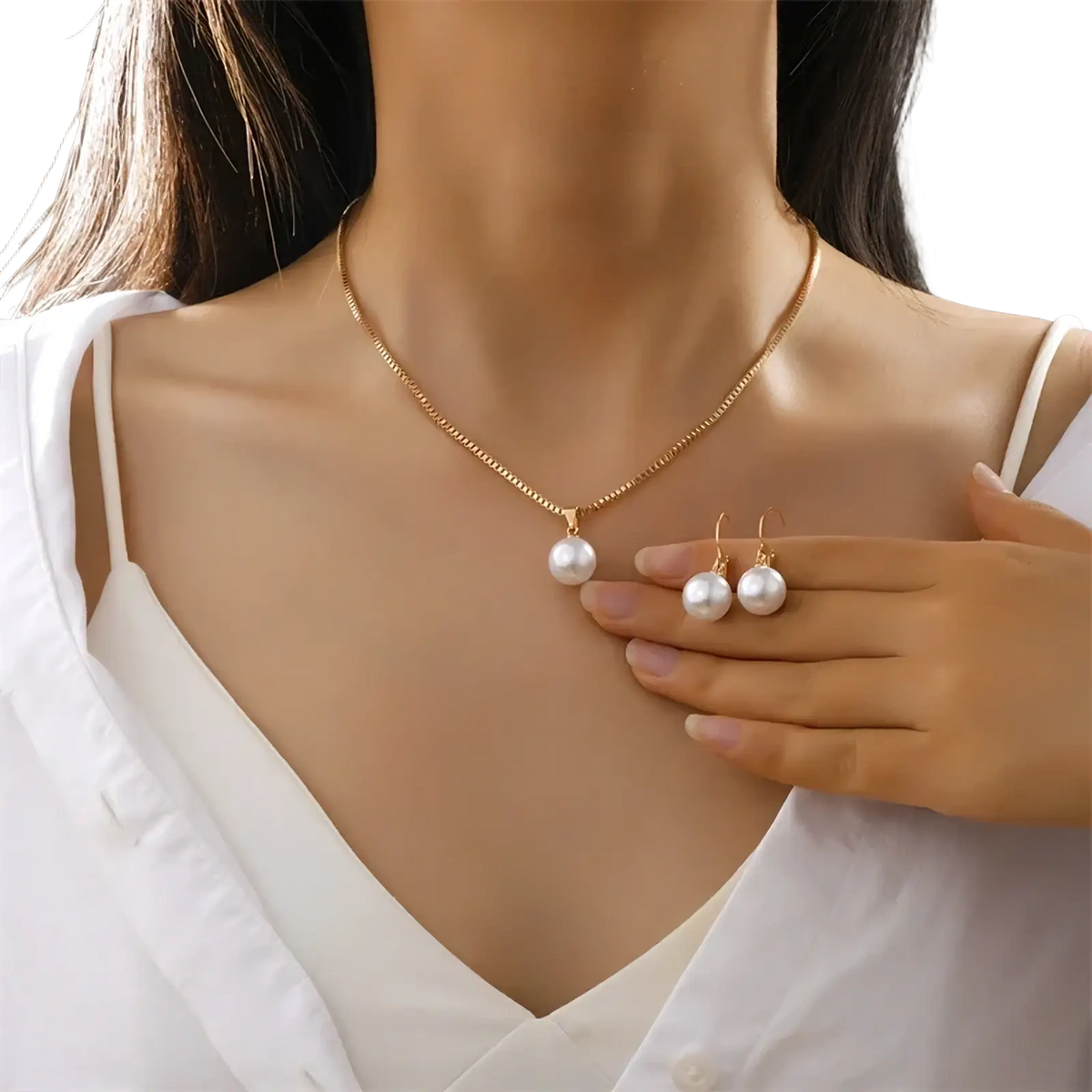 A pearl jewelry set featuring a delicate rose gold chain necklace with a round white pearl pendant and matching earrings