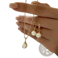 Pearl jewelry set featuring a rose gold pendant necklace and hoop earrings with white pearl drops