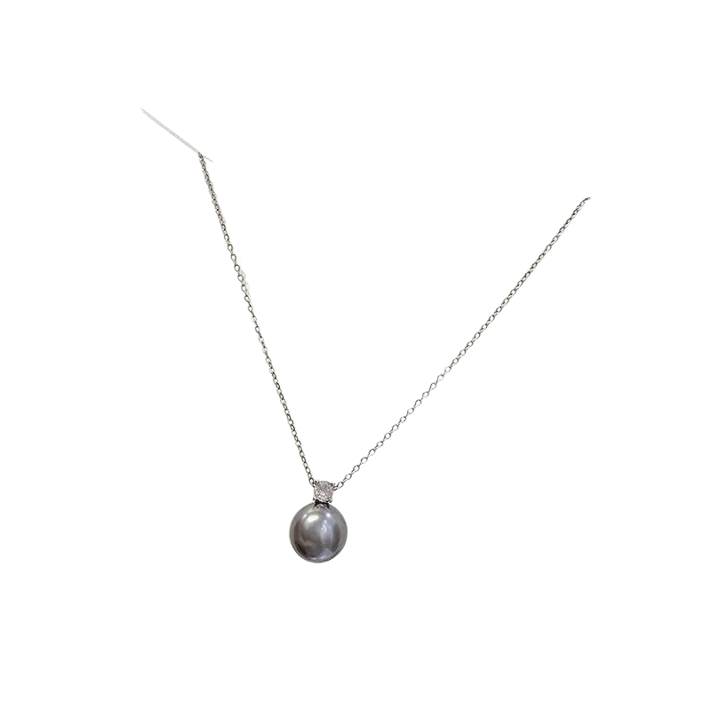 A silver clavicle chain necklace with a single gray pearl pendant and a small diamond accent at the top