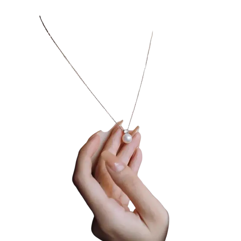 A delicate silver chain necklace with a single white pearl pendant and small diamond accent