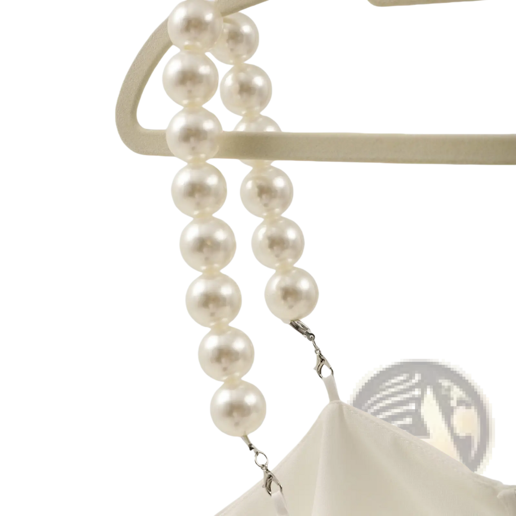 A cream-colored imitation pearl strap with silver clasps on a white pearl strap satin crop top