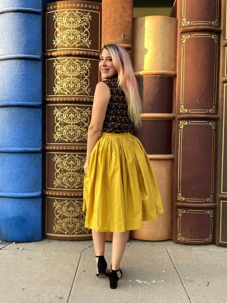 A vibrant mustard yellow 1950s cotton swing skirt with a full silhouette gathered waistband and pockets