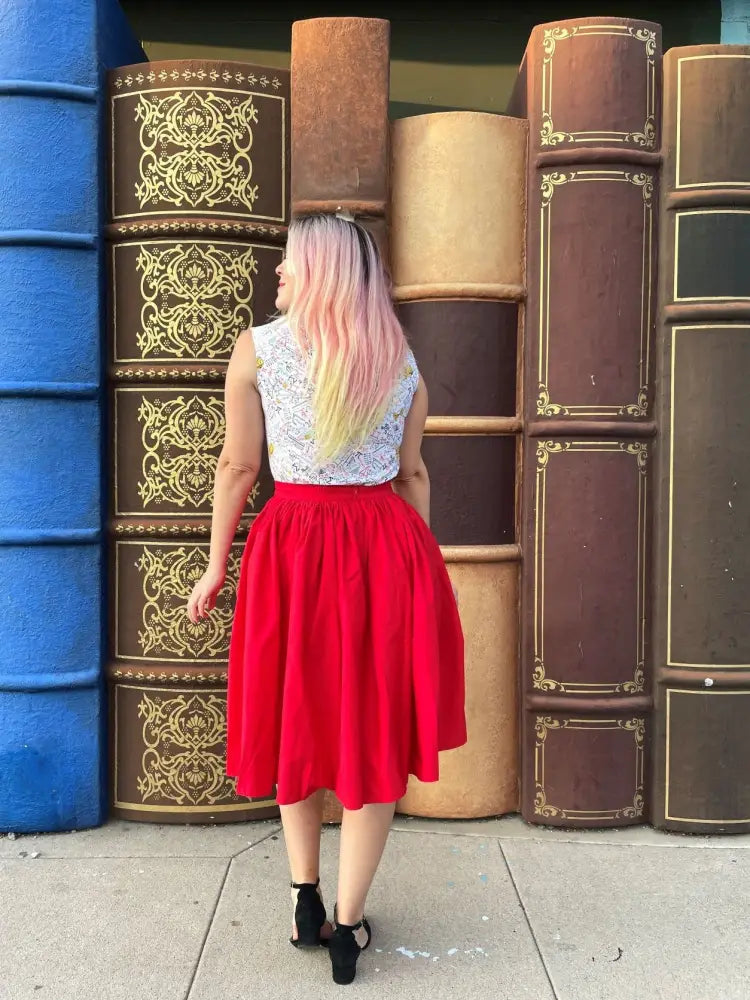 A vibrant red cotton midi swing skirt with a high waist and full soft skirt featuring pockets