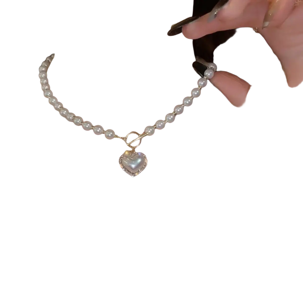 Delicate simulated pearl pendant necklace with heart-shaped iridescent pendant and gold-toned bead accents