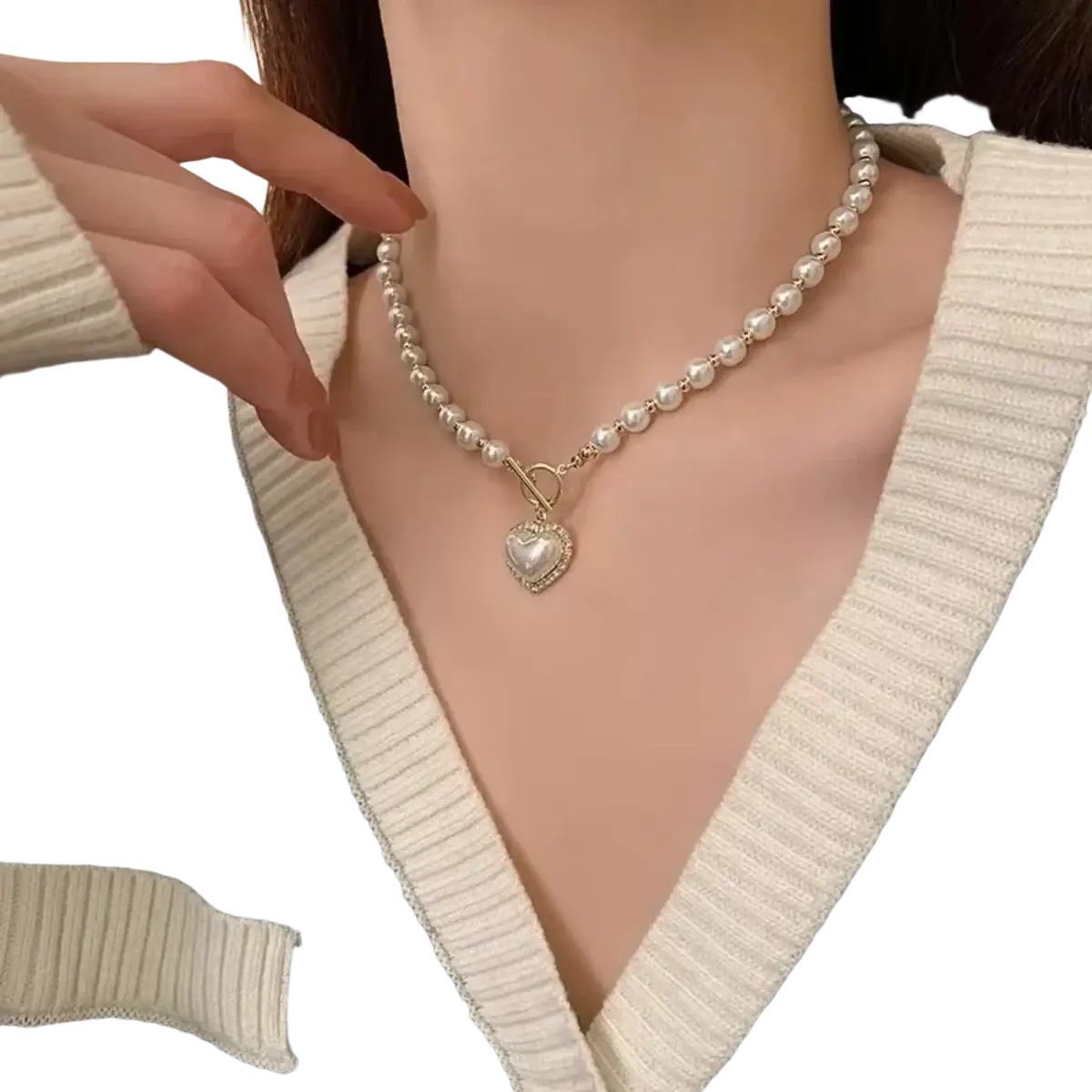 A delicate simulated pearl pendant necklace with a gold-toned toggle clasp and a heart-shaped stone encrusted pendant
