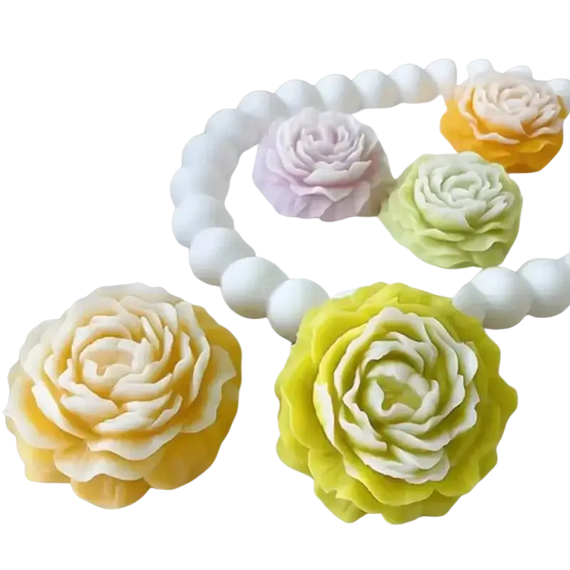 Pastel-colored rose-shaped candles in soft yellow green and lavender made with peony silicone candle mold for diy floral crafts