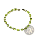 A delicate gold toned peridot sterling silver tennis bracelet with oval cut stones in a classic link design