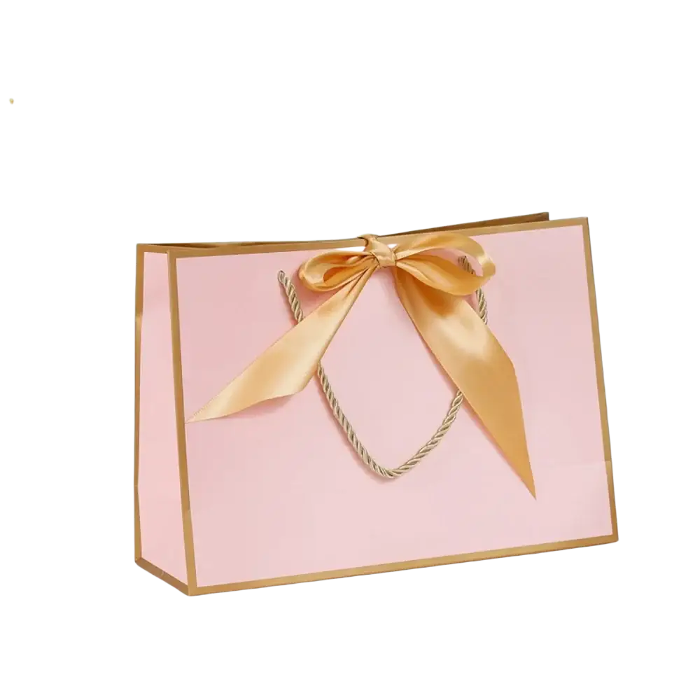 A pink personalized bridesmaid gift bag with gold trim and satin ribbon bow for custom name presentation