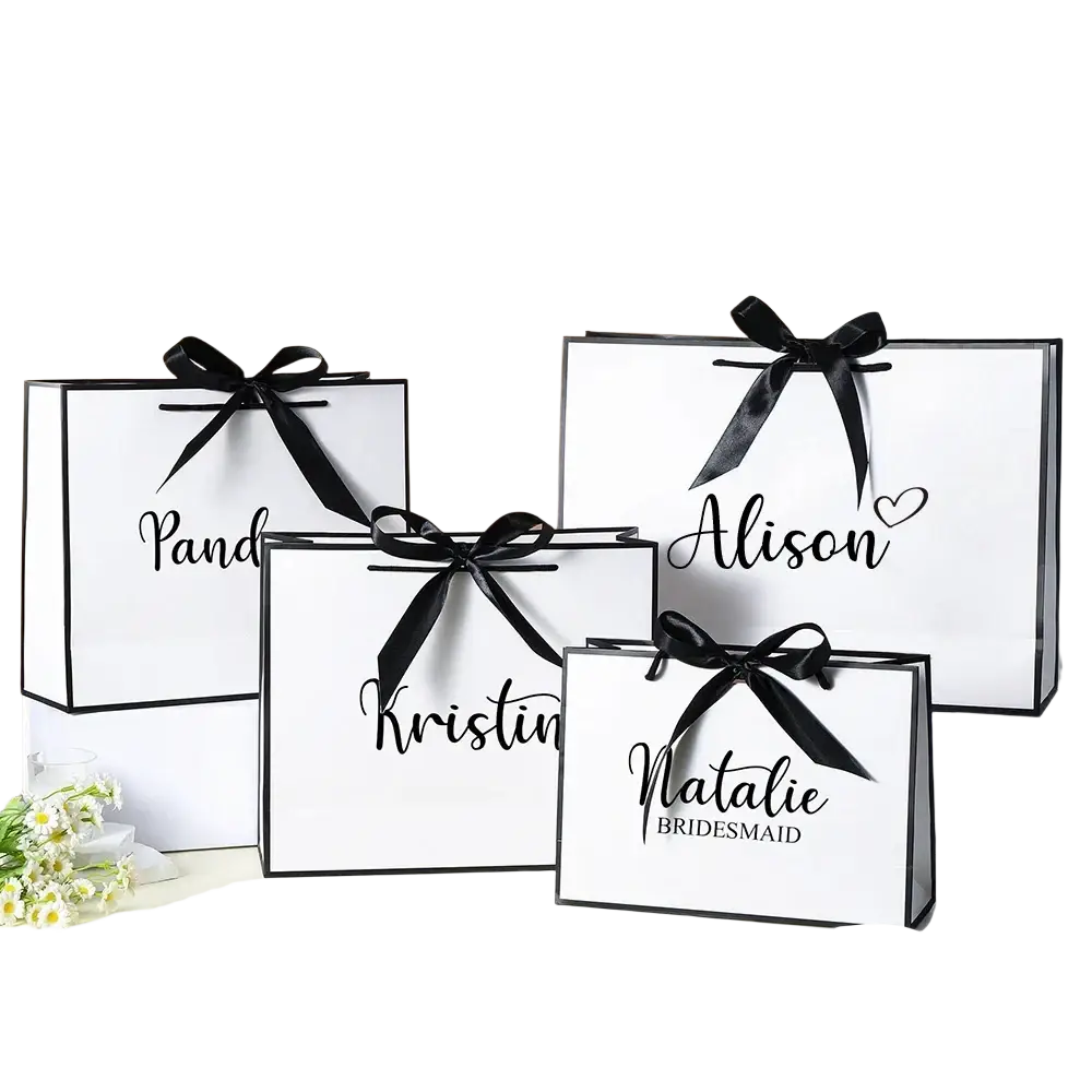 Personalized bridesmaid gift bags white paper with black ribbons and custom elegant cursive names for weddings