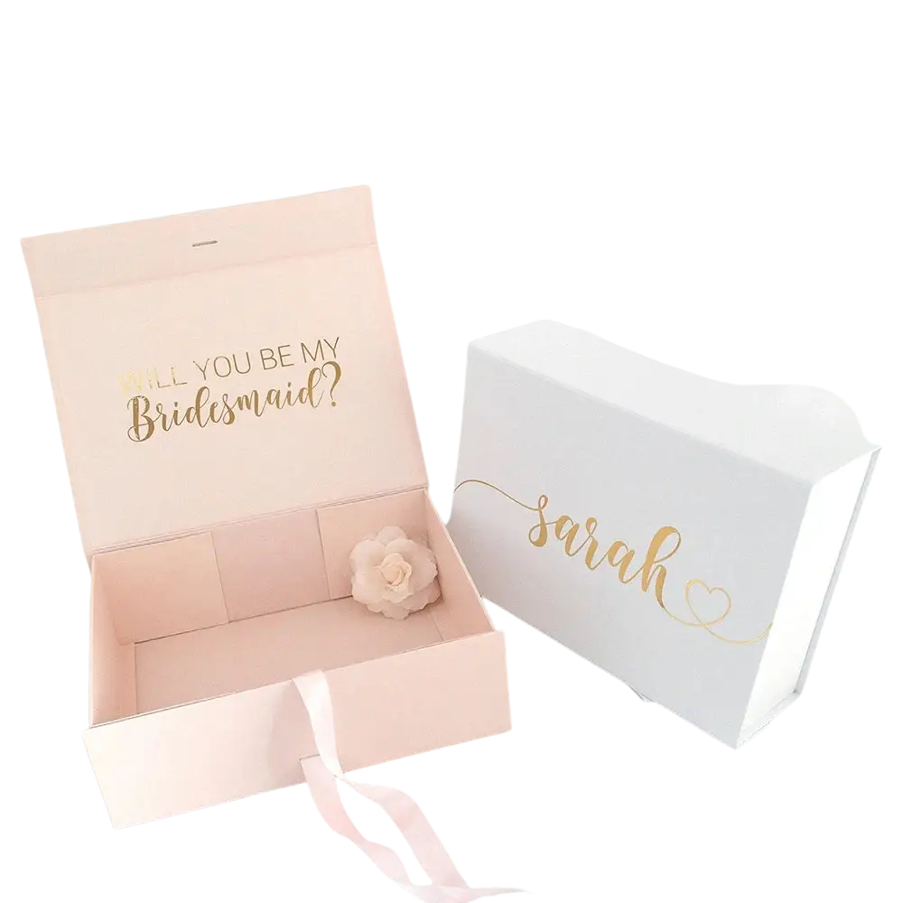 Personalized pink bridesmaid proposal gift box with gold foil lettering and white flower next to white box named sarah