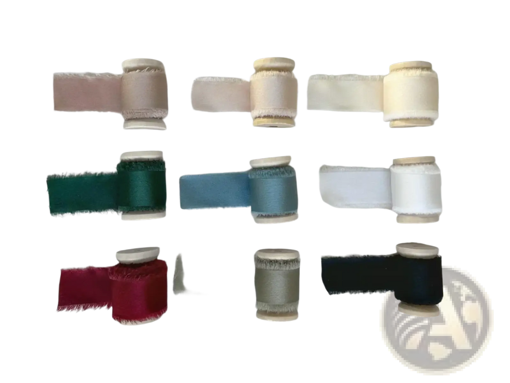 A collection of spools with frayed-edge ribbon in various colors for a personalized minimalist wedding letter books set
