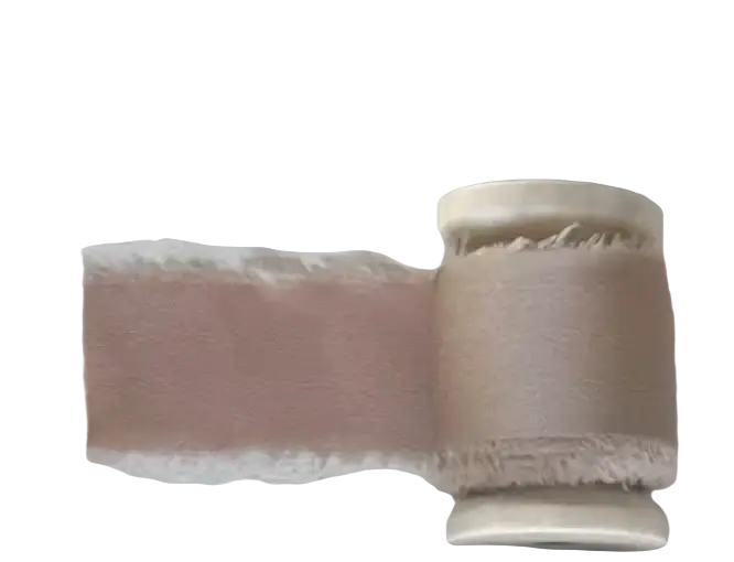 Dusty pink fabric swatch on spool with frayed edges for personalized minimalist wedding letter books set material sample