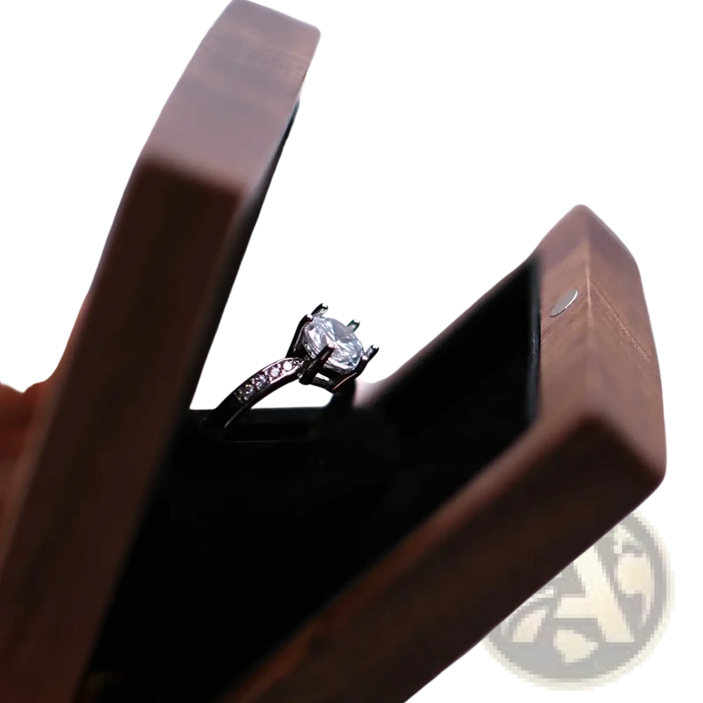 A sleek silver engagement ring with round-cut diamond displayed in an open personalized walnut wood wedding ring box