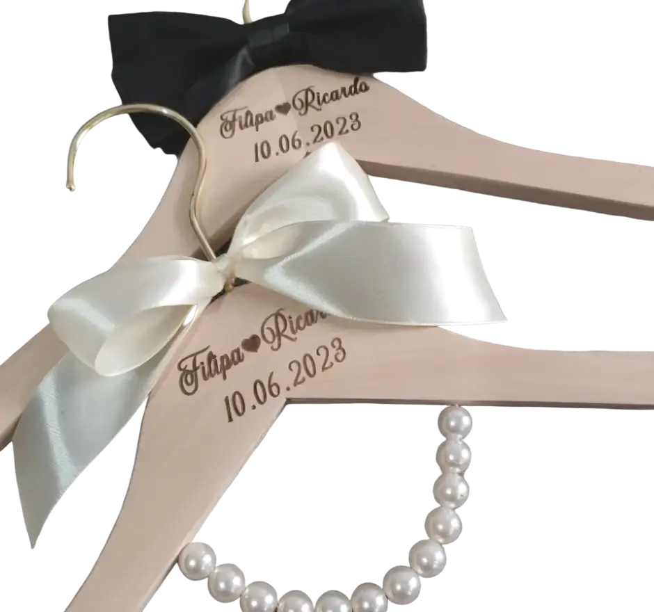 Personalized beige wooden wedding dress hanger custom engraved with names and date, adorned with satin bows and a pearl necklace