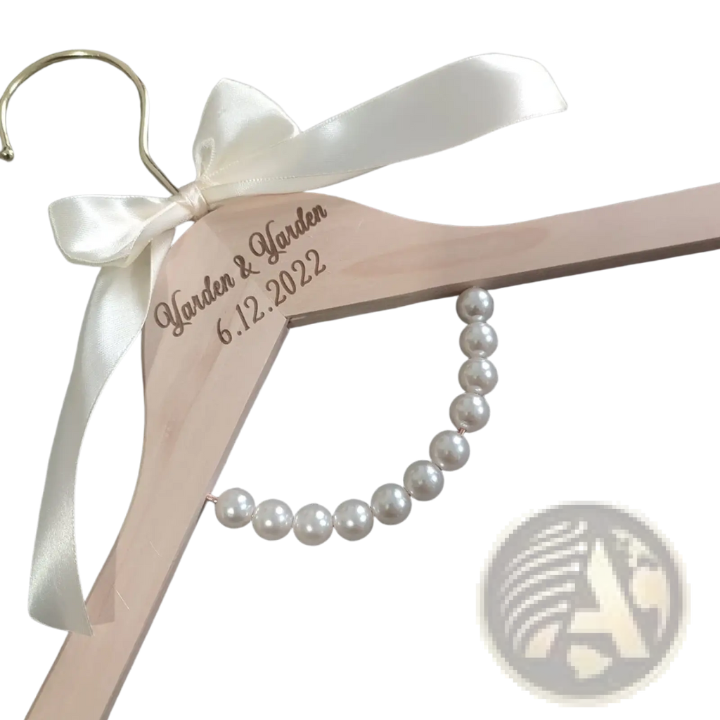 Personalized light pink wooden wedding dress hanger with white satin bow and custom engraving for bridal use
