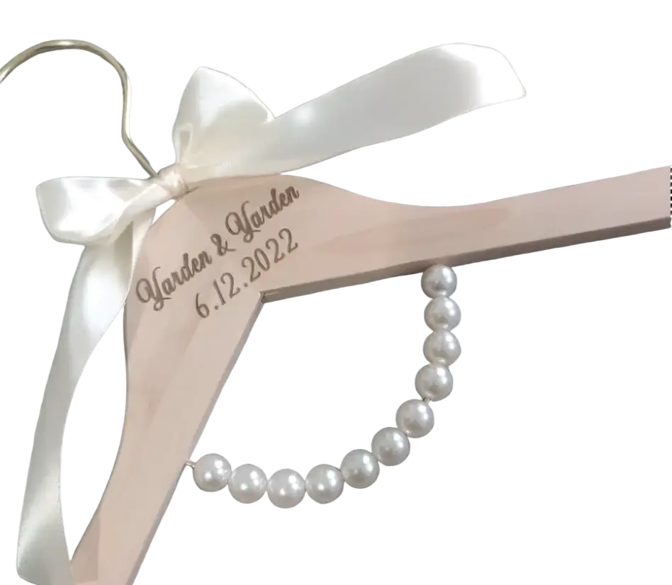 Personalized light pink wooden wedding dress hanger with white satin bow, engraved garden garden 6.12.2022, and pearl beads